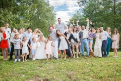 photo de groupe des mariés et leurs amis bras en l'air souriant et grimaçant au bord du lac à la Rochette