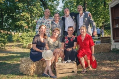 photo de petit groupe de parents des mariés souriant dans un décor champêtre