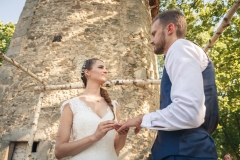 mariée passant l'alliance au doigt de son époux pendant une cérémonie laïque en extérieur