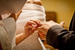main de la mariée passant l'alliance au doigt de son époux à l'église