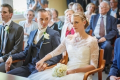 jeune marié souriant regardant son épouse assis en lui tenant la main