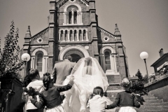enfants tenant la traine de la robe de mariée au pied de l'église