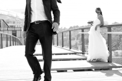 marié s'éloigne de son épouse sur la passerelle de la confluence à Lyon la cravate soulevée par le vent