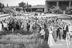 photo de groupe en noir et blanc en vue plongeante des mariés et leurs familles et amis dans le parc du domaine de Sarson à Grignan dans la Drôme provençale