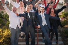 photo de groupe d'un couple d'hommes mariés et leurs amis bras en l'air dans des escaliers