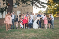 photo de groupe des amis des mariés souriant dans le parc du château de leur mariage