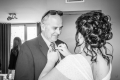 future mariée ajustant la cravate de son père qui lui sourit