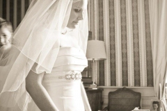 future mariée fin prête sous son voile et une superbe ceinture ornée de diamants qui entoure sa robe blanche dans la chambre du château familial décorée avec des meubles d'époque