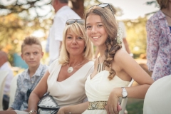 jolie jeune fille et sa mère en robes de cocktail sourient à l'objectif du photographe